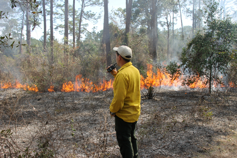 the NATL burn boss using a walkie talkie to communicate with his team