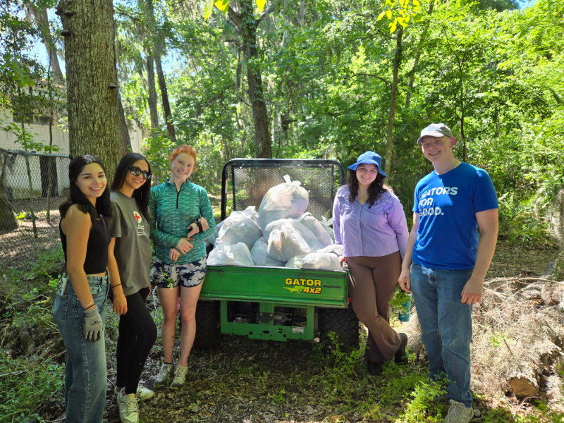 volunteers standing next to bags of trash
