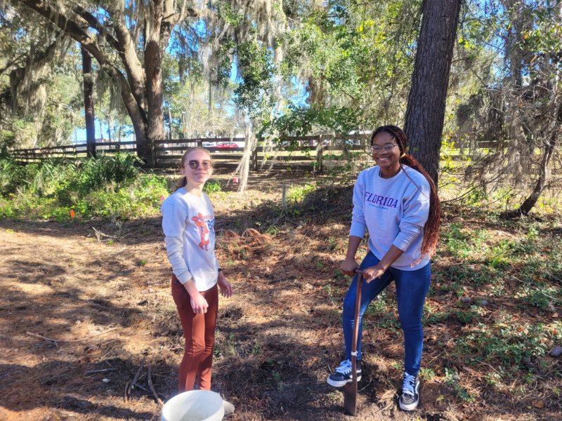 two students planting native grasses